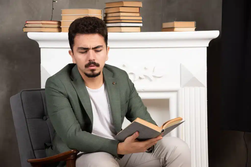 confident handsime man reading book sofa